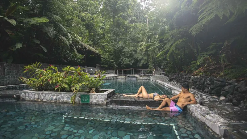 Visitors soaking in a rainforest hot springs pool at Ecotermales near La Fortuna, Costa Rica
