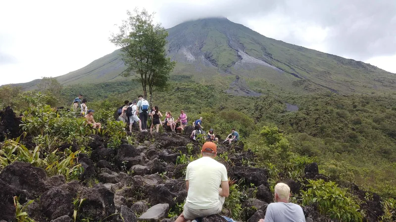 Hikers soaking in the Río Choyin natural hot springs river after an Arenal Volcano hike near La Fortuna, Costa Rica