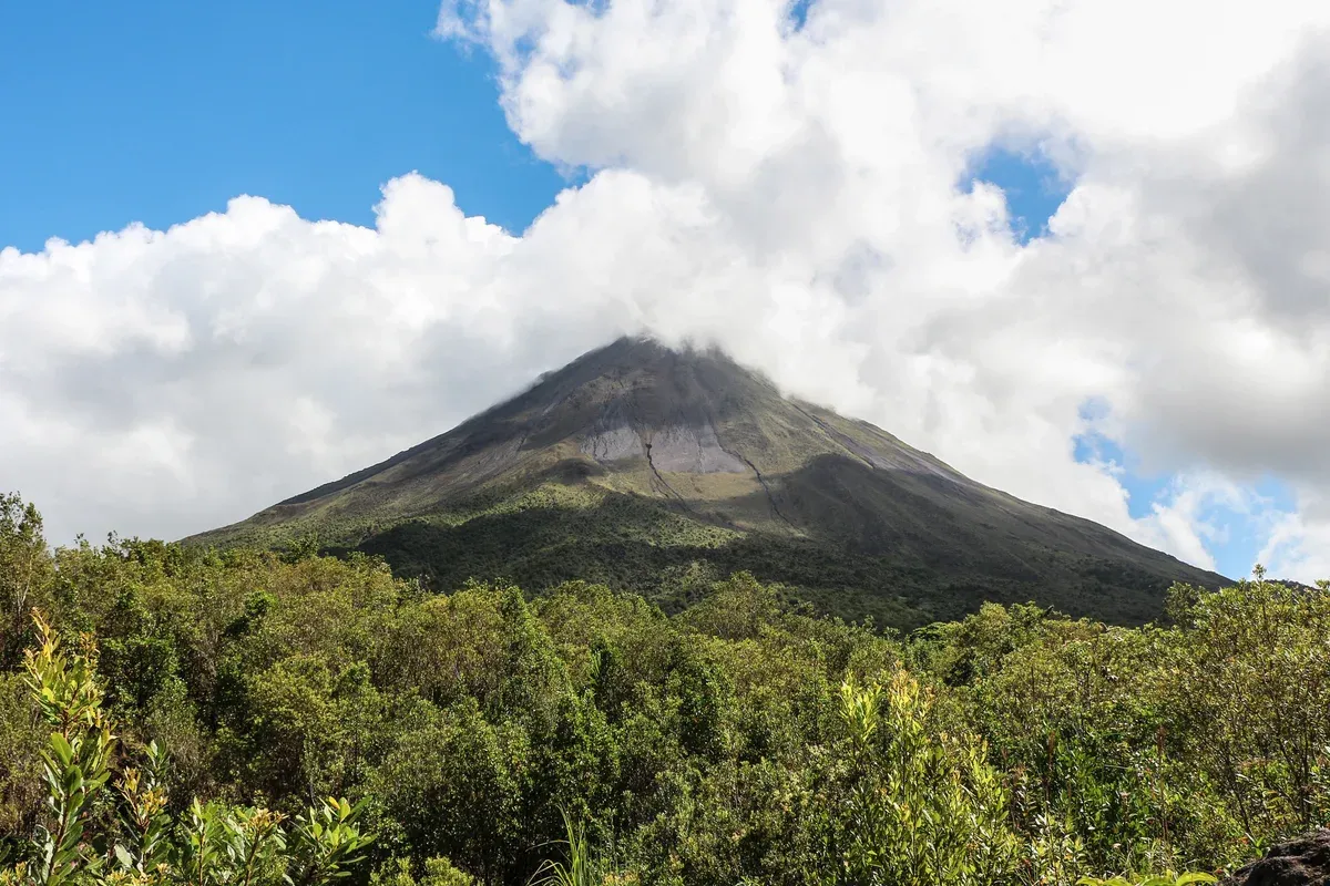 Arenal Volcano with a cloud on the summit above the rainforest, the source of the hot springs in La Fortuna, Costa Rica